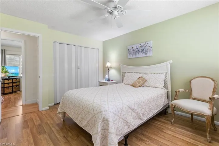 Bedroom featuring wood finished floors, a closet, a ceiling fan, and a textured ceiling