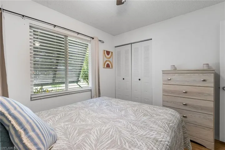 Bedroom featuring a closet, a textured ceiling, ceiling fan, and wood finished floors