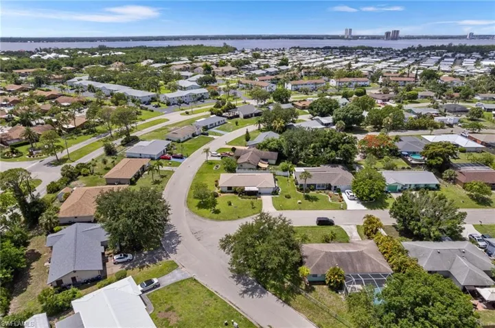 Aerial view of residential area with a nearby body of water and a notable bridge