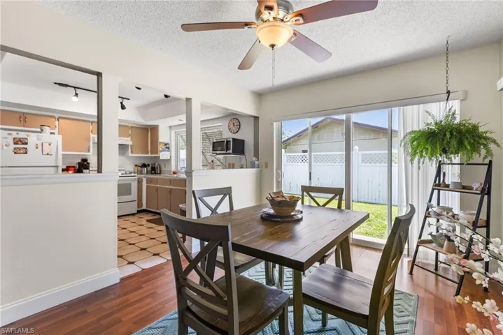 Dining space with a textured ceiling, light wood-style floors, and a ceiling fan
