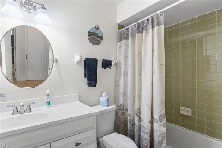 Bathroom with vanity and shower / bath combination with curtain