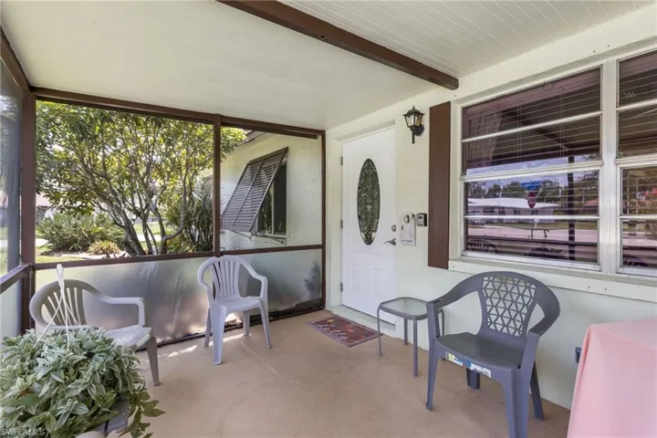 Doorway to property with covered porch and stucco siding