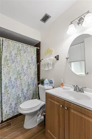 Bathroom featuring wood finished floors, vanity, and curtained shower