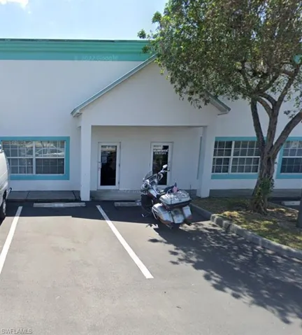 View of front of property with stucco siding and uncovered parking