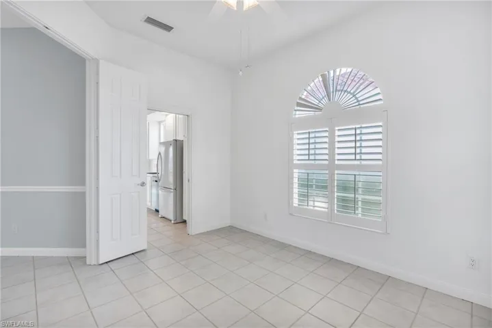 Tiled empty room featuring ceiling fan