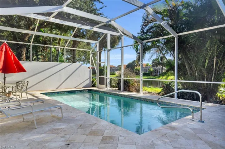 View of pool with a lanai, a patio area, and a water view