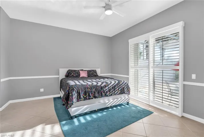 Tiled bedroom featuring ceiling fan