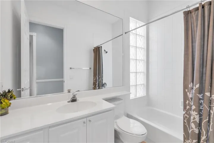 Full bathroom with vanity, toilet, and shower / tub combo with curtain