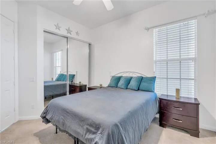 Bedroom with a closet, ceiling fan, and light colored carpet