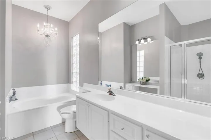 Full bathroom featuring tile patterned flooring, vanity, toilet, and separate shower and tub