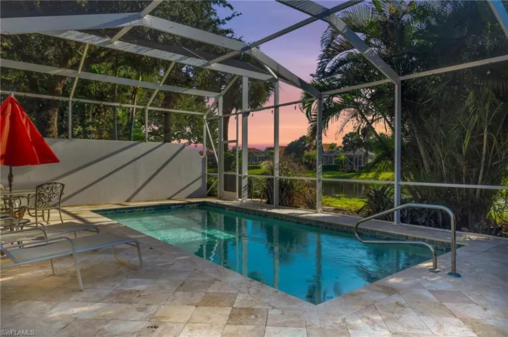 Pool at dusk with a patio and a lanai