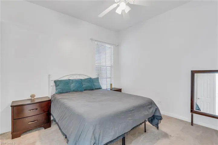 Carpeted bedroom featuring ceiling fan