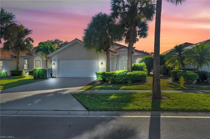 View of front of home with a garage, a lawn, and central air condition unit