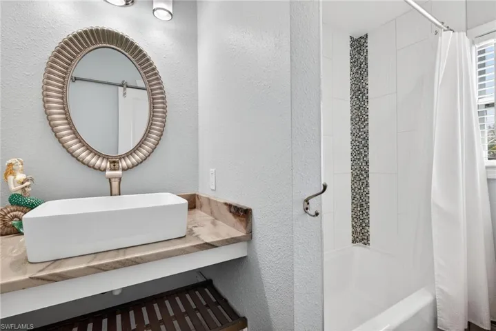 Updated guest bathroom with tiled tub/shower combo and a window for natural light