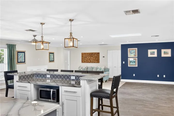 Spacious open-concept interior featuring a patterned tile backsplash and quartzite countertops
