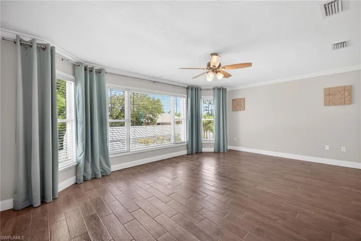 Spacious primary suite featuring a large bay-like window with crown molding