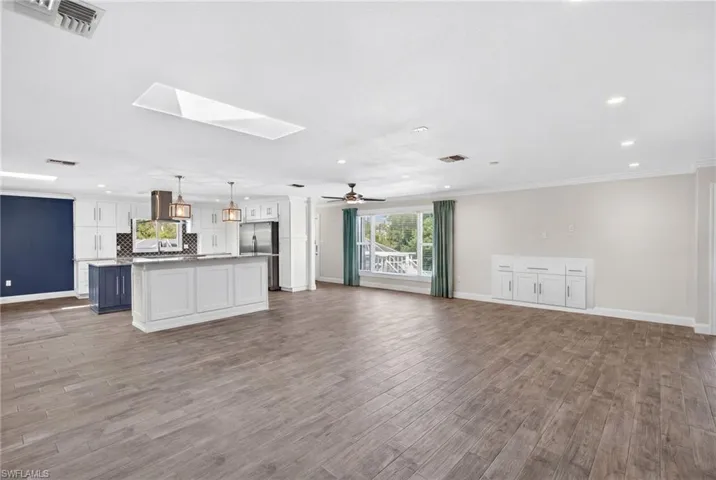 Large open living area with skylights, big picture window, and storage for under the TV.