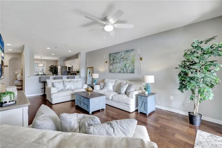 Living room with ceiling fan and dark hardwood flooring.
