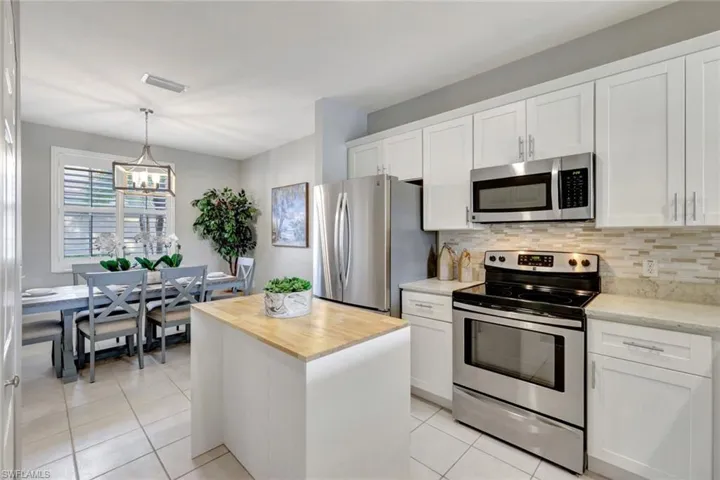 Large ktchen featuring appliances with stainless steel finishes, a center island, and white cabinetry