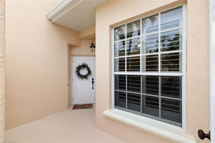 View of front porch entrance inside white gate.