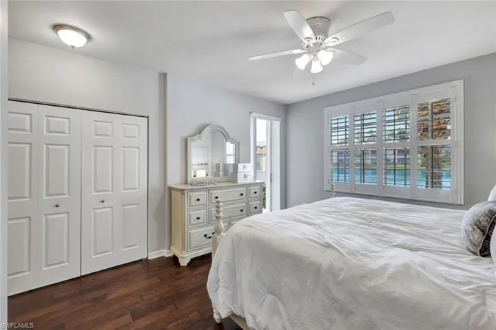 Bedroom with dark hardwood / wood-style flooring, a closet, and ceiling fan