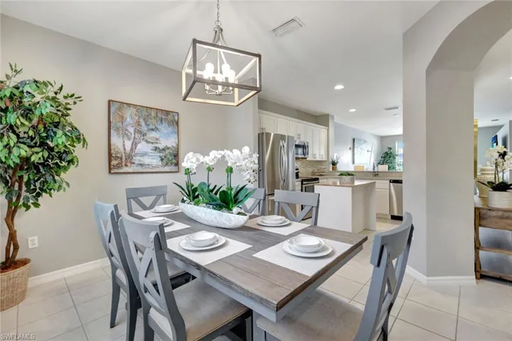Lovely tiled dining space w/window featuring an inviting chandelier