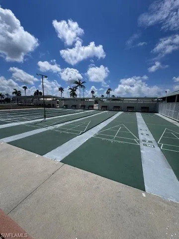Multiple shuffleboard courts with marked playing areas, perimeter benches, and integrated lighting fixtures