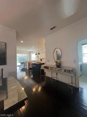 Dining space featuring ornamental molding and dark wood finished floors