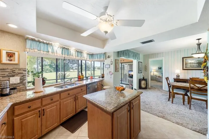 Kitchen with plenty of natural light, light tile patterned floors, a kitchen island, and ceiling fan