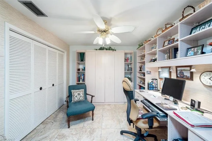Office with light tile patterned floors and ceiling fan