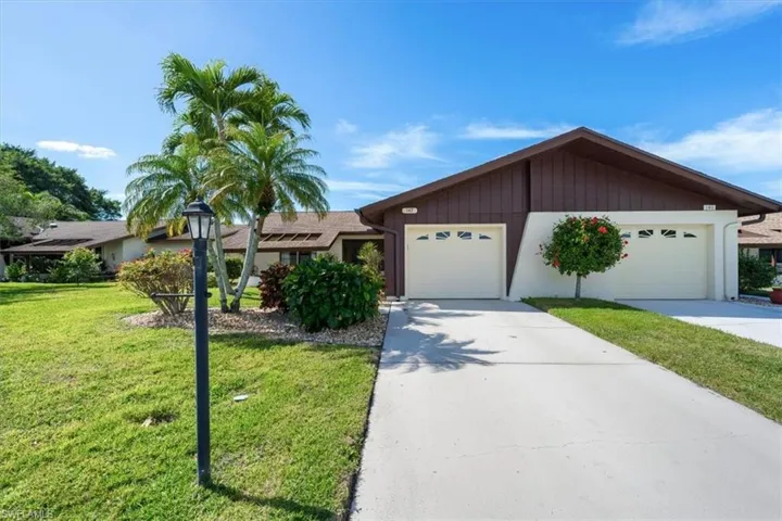 Ranch-style house with a garage and a front lawn