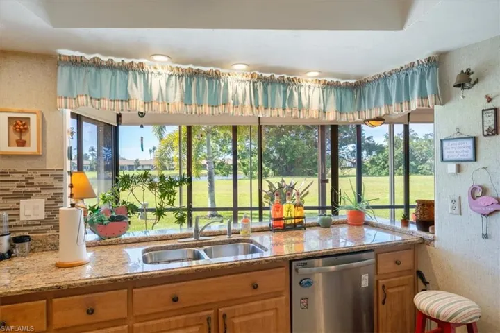Kitchen featuring tasteful backsplash, a wealth of natural light, sink, and stainless steel dishwasher