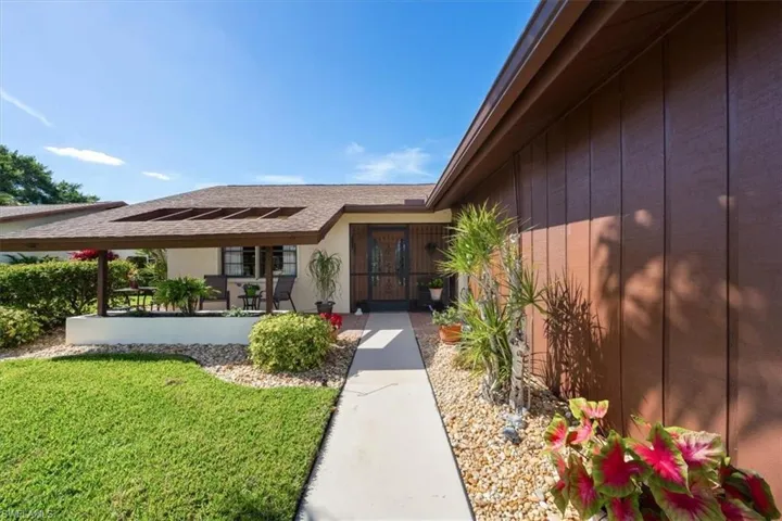 Entrance to property with a patio area and a yard
