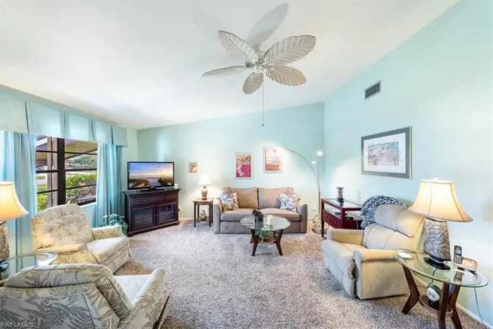 Living room with carpet floors and ceiling fan
