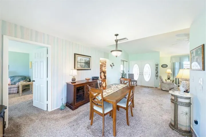 Carpeted dining space featuring ceiling fan
