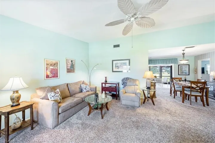 Carpeted living room with ceiling fan