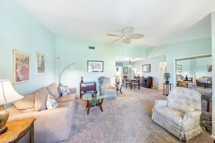 Carpeted living room featuring ceiling fan