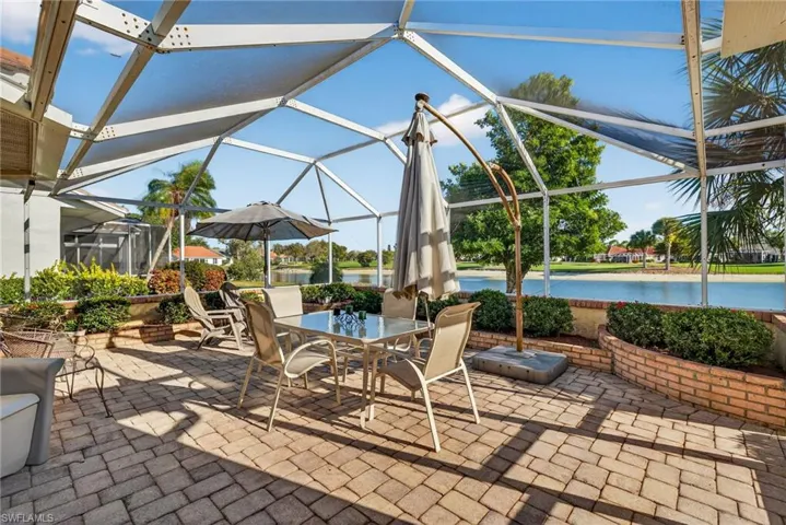View of patio / terrace featuring a lanai, a water view and golf course views