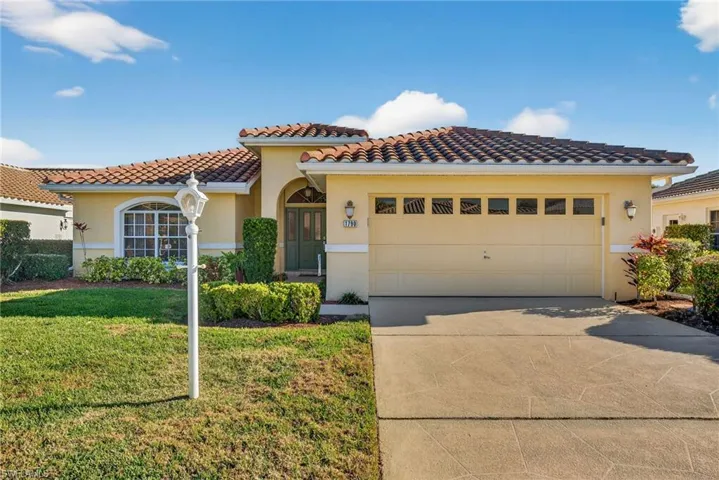 Mediterranean / spanish-style house featuring a front yard, stucco siding, concrete driveway, a garage, and a tile roof