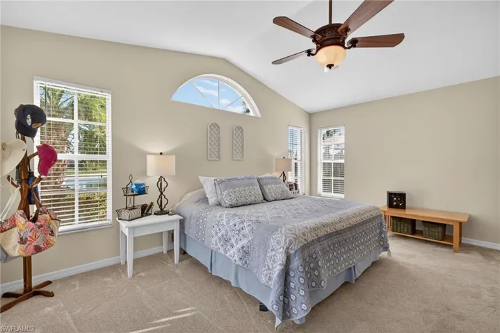 Carpeted bedroom with lofted ceiling and a ceiling fan