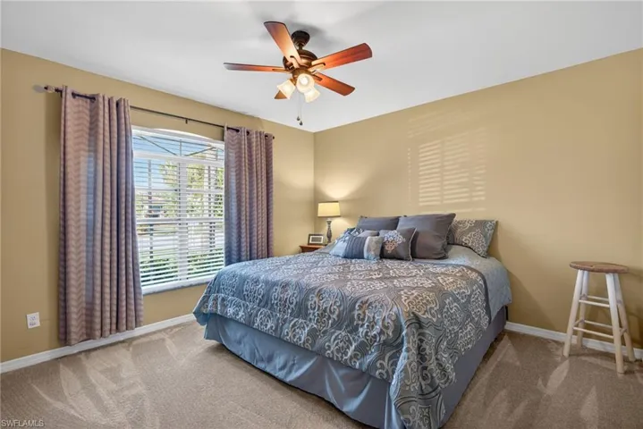 Carpeted bedroom featuring baseboards and ceiling fan
