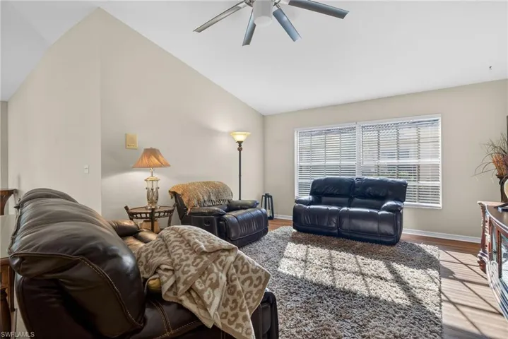 Living room featuring wood finished floors, lofted ceiling, and ceiling fan