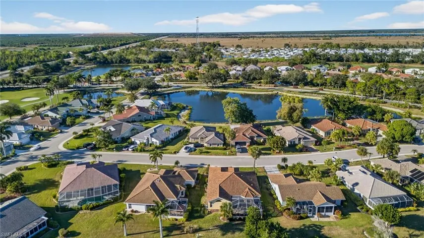 Aerial view of property and surrounding area featuring a nearby body of water and nearby suburban area