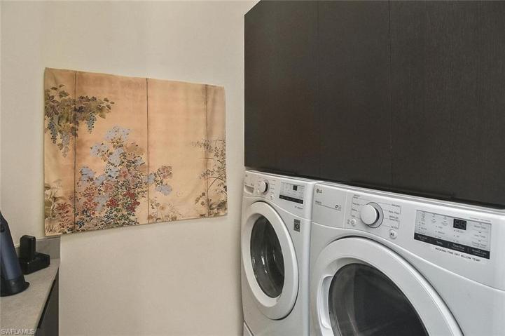 Laundry Room with front loading washer, dryer, and storage cabinets
