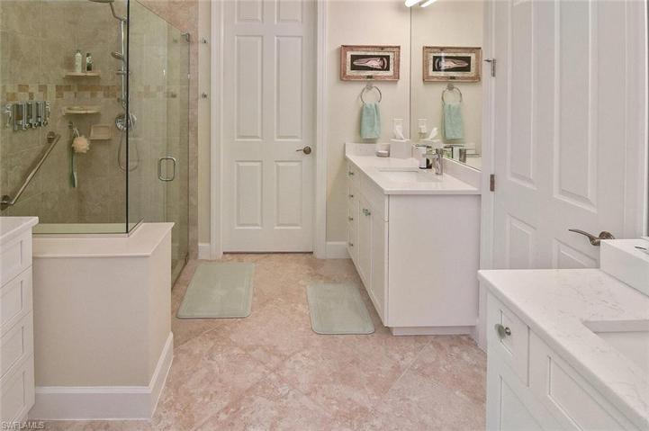 The updated Primary Ensuite" with dual sink vanities, walk-in shower, private water closet, custom cabinetry, and huge walk in closet.