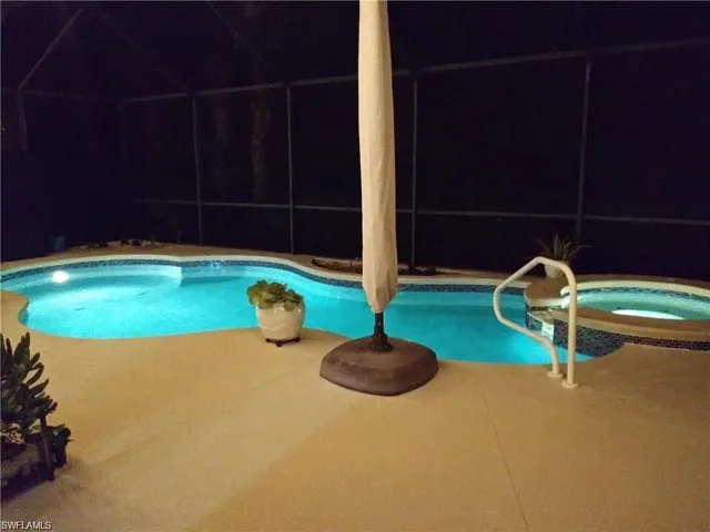 Integrated pool / spa with glass enclosure, a sunroom, and a patio