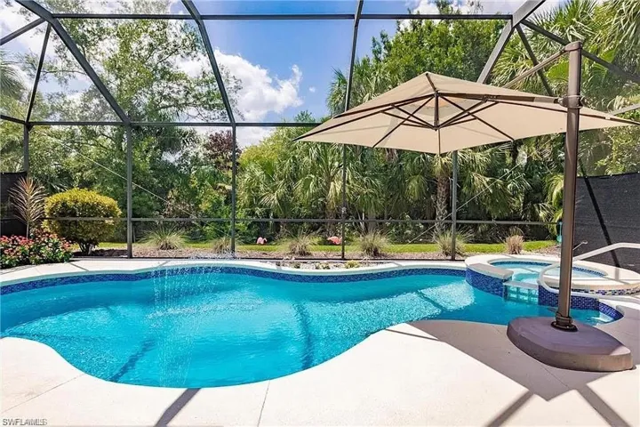Relaxing pool / spa featuring glass enclosure and a sunroom