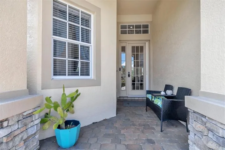 View of exterior entry featuring stucco siding and a patio