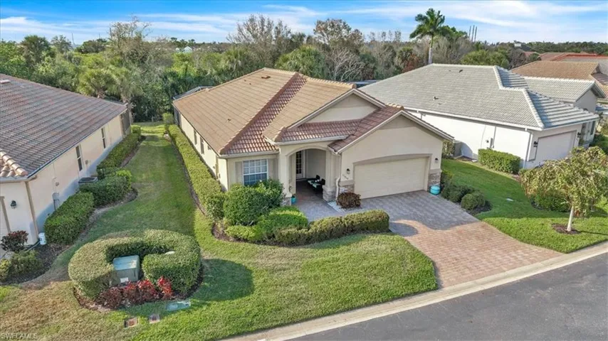 Mediterranean / spanish-style home with stucco siding, a tile roof, an attached garage, and a front yard