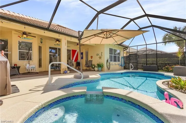 Integrated pool / spa featuring a sunroom, a patio, and a lanai